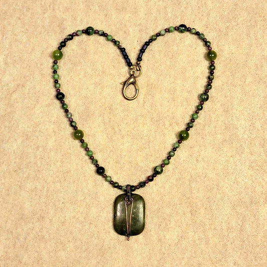 Jade pendant. Surrounded by the rich purples of Sugilite the forest greens of Aventurine & Ruby red of Zoisite.